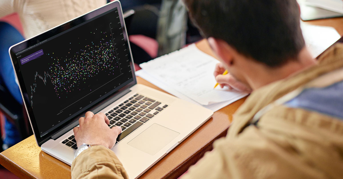 A college student views molecular analysis simulations on a laptop while taking notes.