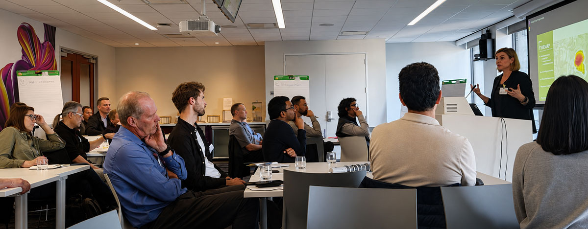 A presentation about FIREMAP being given to a diverse audience seated in a conference setting.